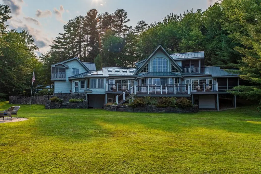 Back of the house at 17 Point Road with level lawn running down to Wilson Lake, Wilton Maine