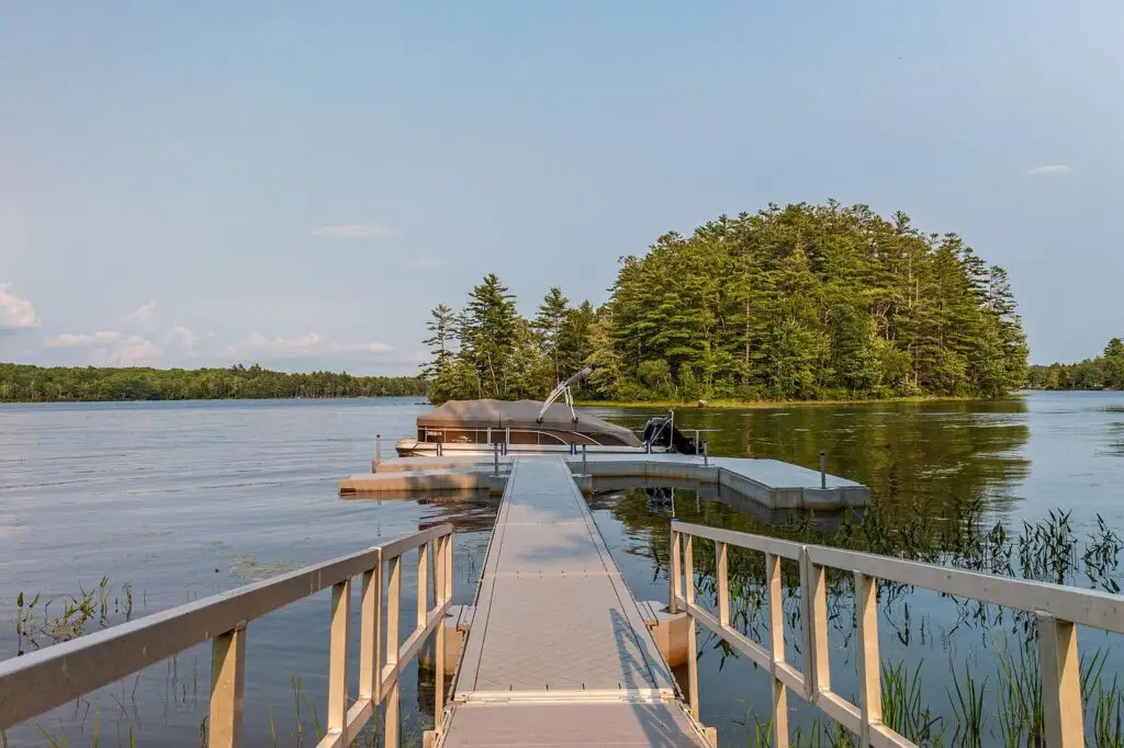 Private dock on Wilson Lake with pontoon boat moored and island beyond