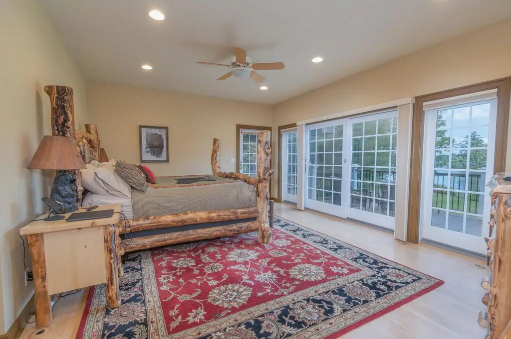First-floor primary bedroom with lake view and private balcony access
