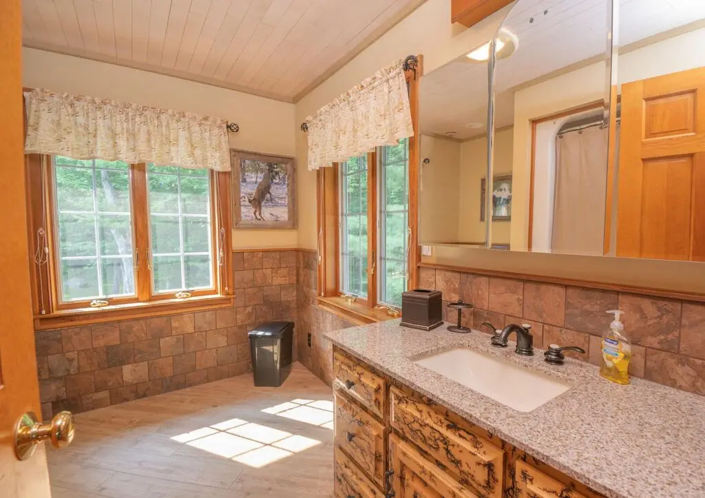 Bathroom vanity beneath windows with natural light