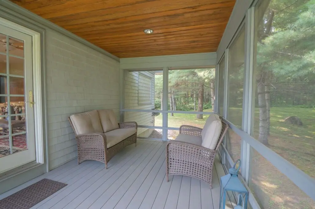Screened porch seating area facing the water