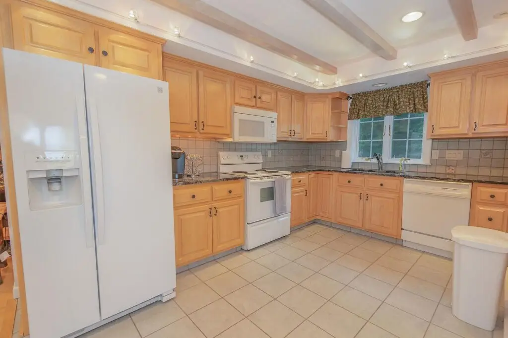 Guest apartment kitchen with white appliances and eat-in dining
