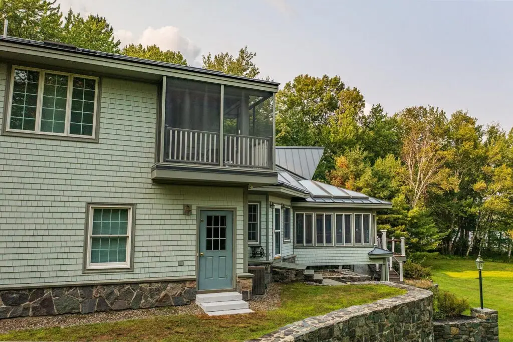 Screened porch and stonework on the lake side of the house