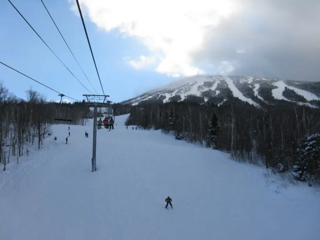 Skiers on a groomed trail below a chairlift at Sugarloaf Mountain, Carrabassett Valley, Maine